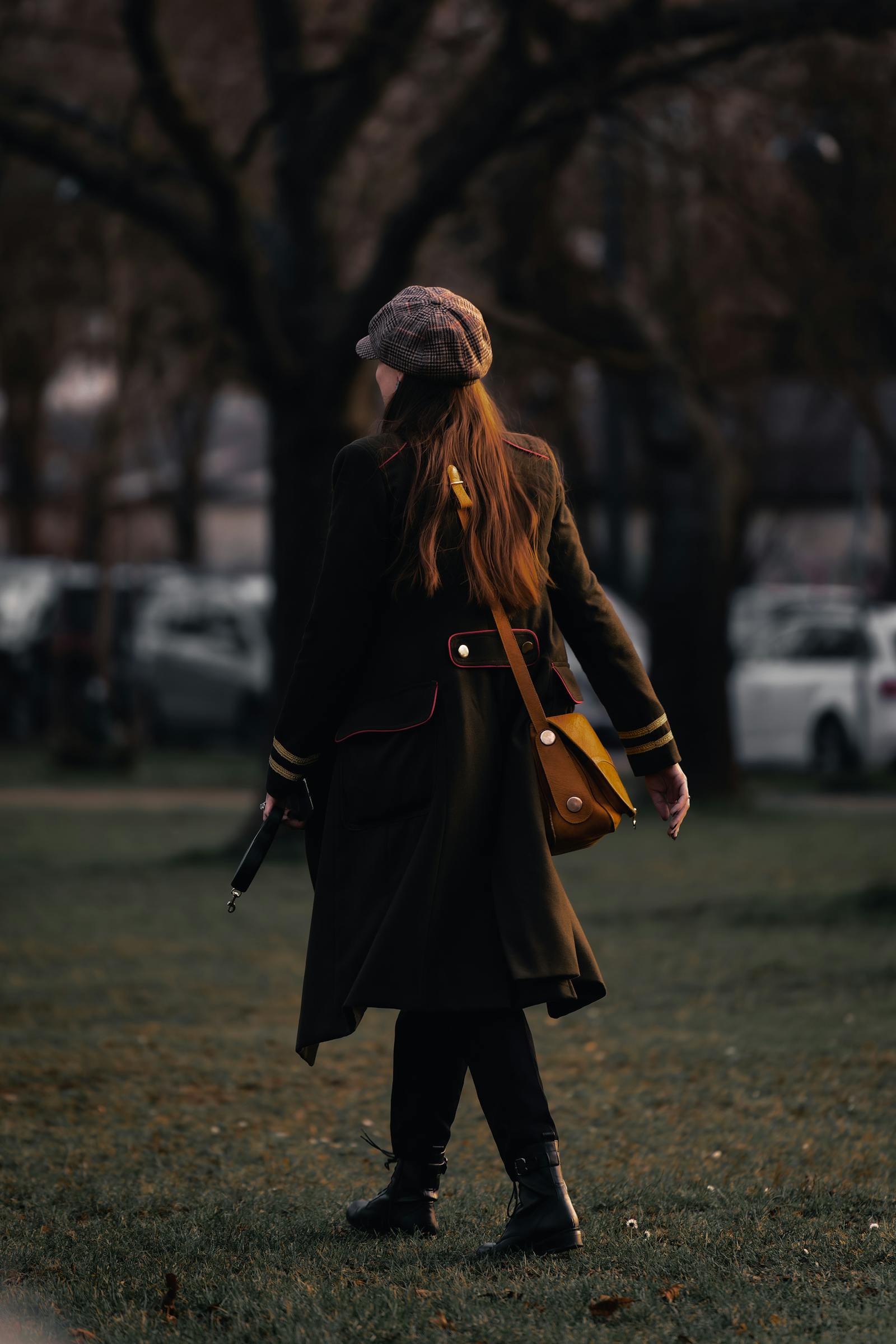 Woman in stylish attire walking in a Vienna park during fall, showcasing seasonal fashion.