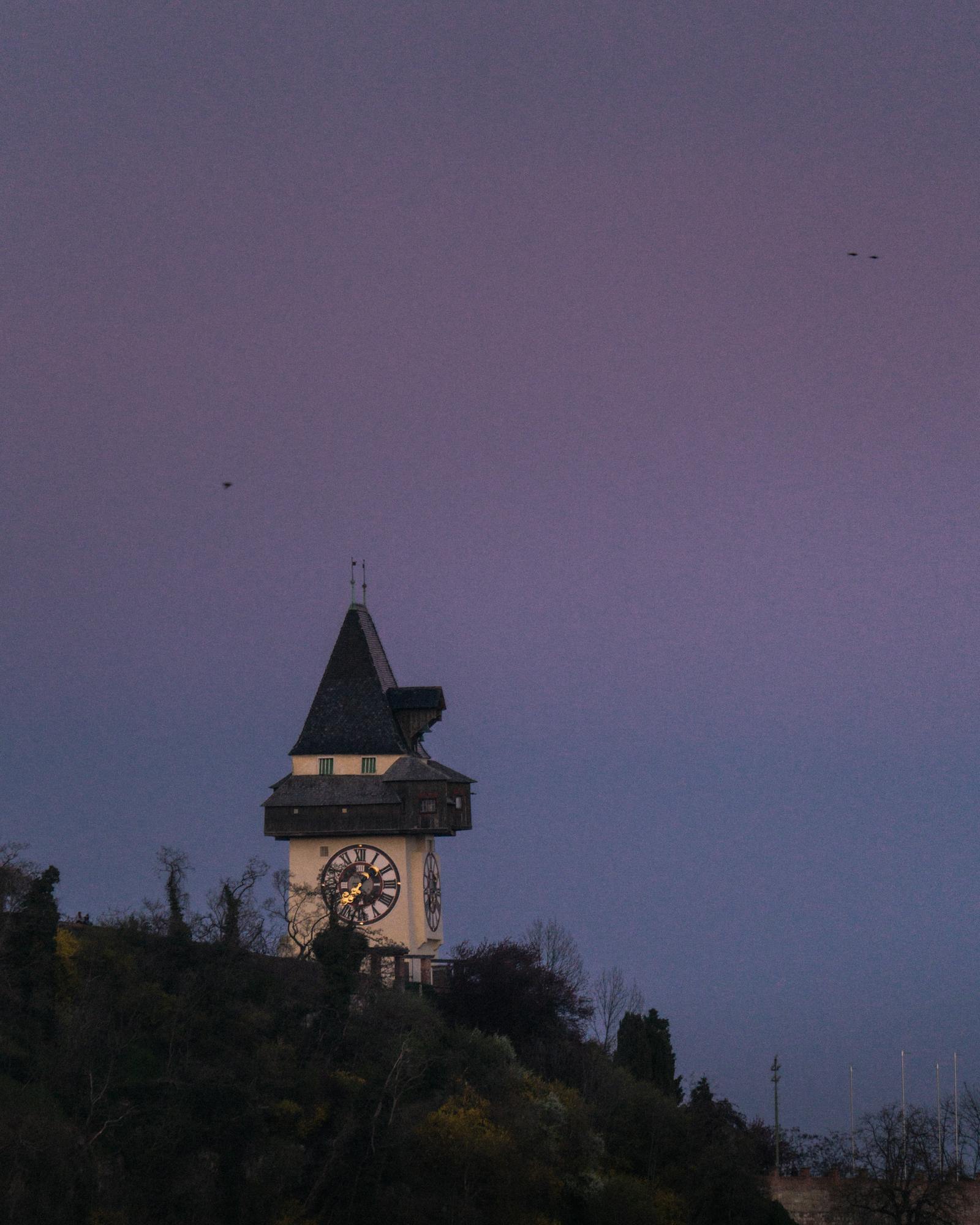 Majestic view of the Uhrturm in Graz, Austria during twilight hours.